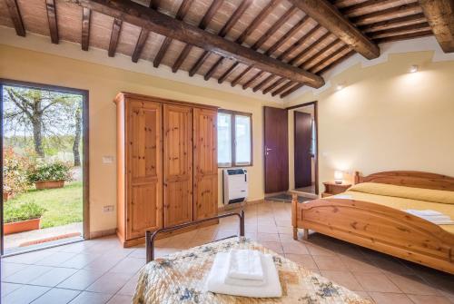 a bedroom with a bed and a large window at Faetino - Pavone in Colle di Val d'Elsa