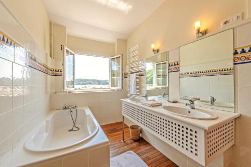 a white bathroom with a tub and a sink at Évasion marine face à la mer in Plouézocʼh