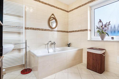 ein Badezimmer mit Badewanne, Waschbecken und Fenster in der Unterkunft Dreamliner in Sassnitz