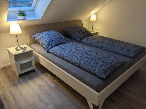 a bedroom with a bed with two lamps and a window at Ferienwohnung Auszeit in Niebüll