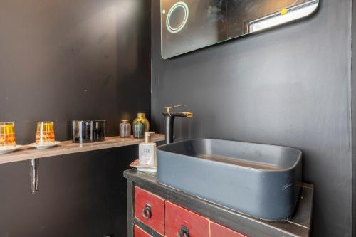 a bathroom with a blue sink on a counter at L'Eclose Chambre Kergoz in Le Guilvinec
