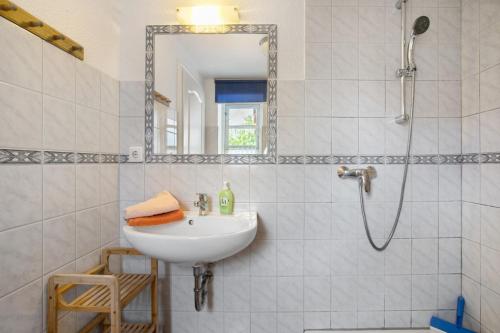a white bathroom with a sink and a mirror at Apartment Eulenhof 2 in Bordelum