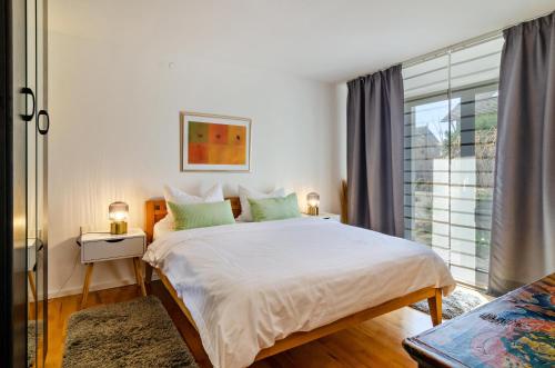 a bedroom with a large bed and a large window at Stella Lilia in Radolfzell am Bodensee