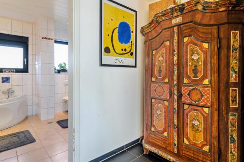 a wooden cabinet in a bathroom with a tub at Stella Lilia in Radolfzell am Bodensee