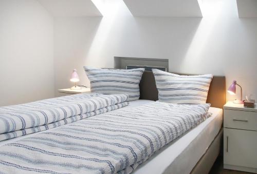 a bedroom with two beds with striped pillows at Obst- und Ferienhof Schäfler in Hattnau