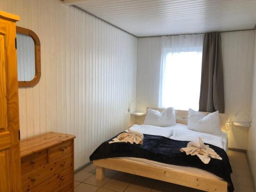 a bedroom with a bed with a window at Bunte Ferienhaussiedlung in Rheinsberg