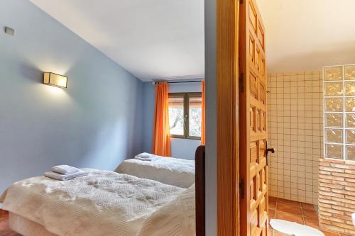 a bedroom with two beds and a window at La Aldeilla in Aldeaquemada