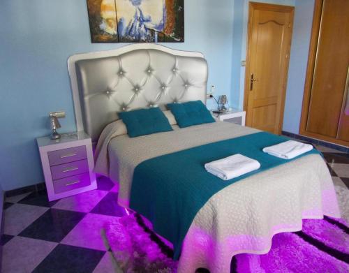 a bedroom with a large bed with purple lighting at Chalet Del Sol in Puerto Lumbreras