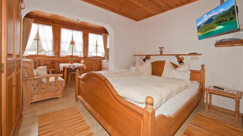 a bedroom with a large wooden bed in a room at Ferienwohnungen Weiß in Mittenwald