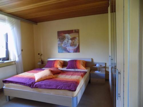 a bedroom with a bed with purple sheets at Ferienwohnung Evi Opp - Harmonie in Brodersdorf
