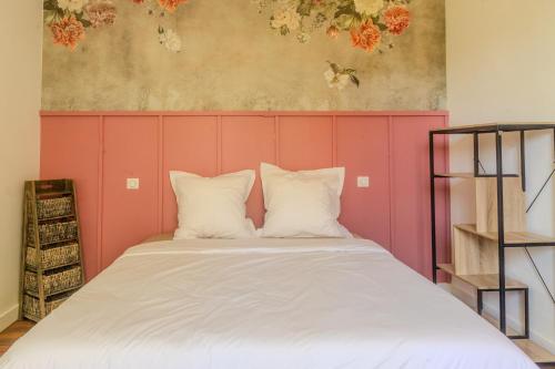 a bed with two pillows in a room at Charmant Cottage - Saint-Junien in Saint-Junien