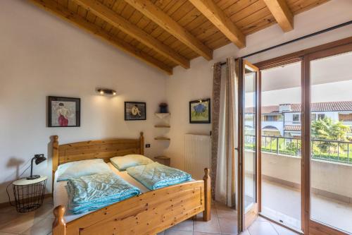 a bedroom with a bed and a balcony at Apt Gardasee Lazise Colá in Colà di Lazise