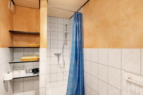 a bathroom with a shower with a blue shower curtain at Ferienwohnung Heike Schreiber in Sasbachwalden