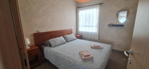 a bedroom with a bed with two towels on it at Apartamento La Palma Corralejo in Corralejo