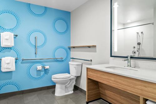 a bathroom with a toilet and a blue wall at Tru By Hilton Hagerstown in Hagerstown