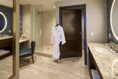 a bathroom with a robe hanging on a door at Choctaw Casino & Resort Durant, a Wyndham Grand Hotel in Durant