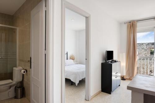 a bedroom with a bed and a bathroom with a window at Surfer Tarifa in Tarifa