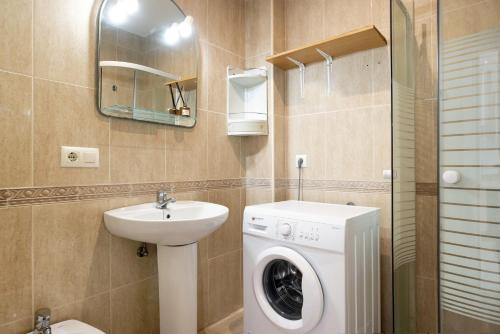 a bathroom with a washing machine and a sink at Surfer Tarifa in Tarifa