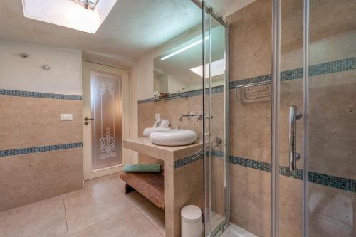 a bathroom with a sink and a glass shower at La Cartapesta in Lecce