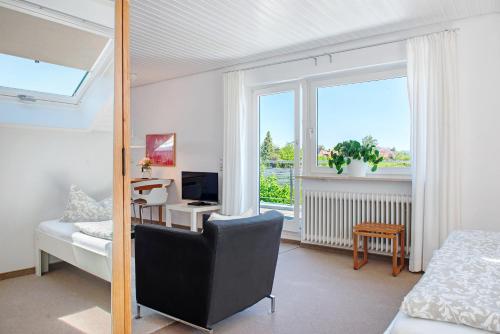 a bedroom with a bed and a television and a window at Ferienwohnungen Riedel in Immenstaad am Bodensee