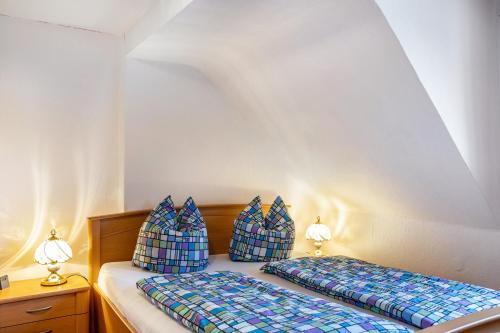 a bedroom with two beds with blue pillows at Haus Edith in Gersfeld