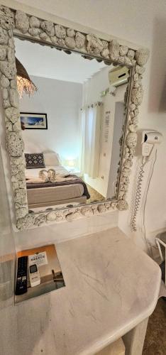 a mirror on the wall of a bedroom with a bed at Santorini Studios Pleasure in Perissa