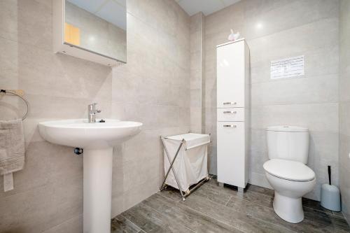 a white bathroom with a sink and a toilet at Casa Lluma in Aldover