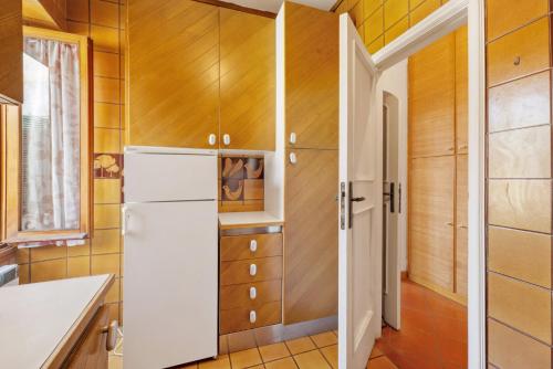a kitchen with a white refrigerator and wooden walls at Luca Via Gavazzo 18 in Bonassola