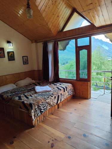 a bedroom with a bed in a room with a large window at Hikers & Bikers in Haripūr