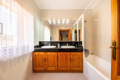 a bathroom with two sinks and a large mirror at Villa Can Andreuet de Baix in Illes Balears