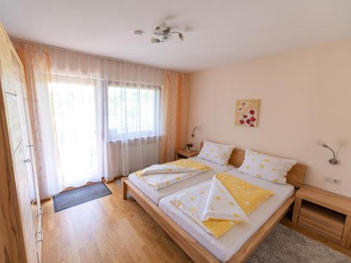 a bedroom with two beds and a large window at Ferienhof Biegger in Tettnang