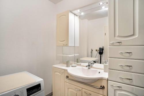 a white bathroom with a sink and a mirror at Reinhards Ferienwohnung in Greifswald