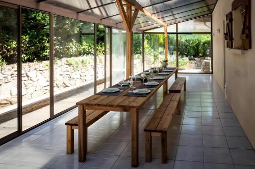 a long wooden table in a room with windows at Chalet Bellevue Vue exceptionnelle in Basse-sur-le-Rupt