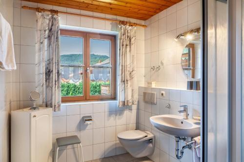 a bathroom with a sink and a toilet and a window at Ferienhaus St Christoph in Mittenwald