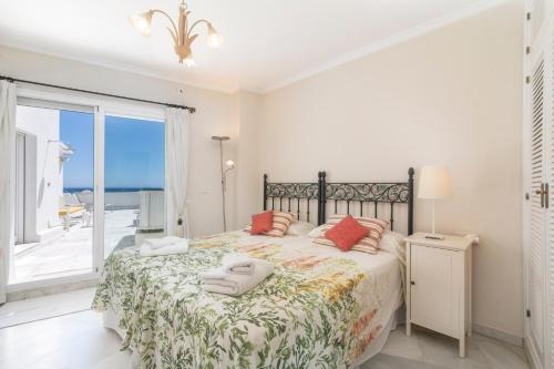 a bedroom with a bed with a view of the ocean at Deluxe Apartment with Jacuzzi in Marbella
