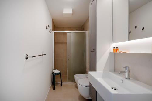 a white bathroom with a toilet and a sink at Dimora Adriatica in Bari
