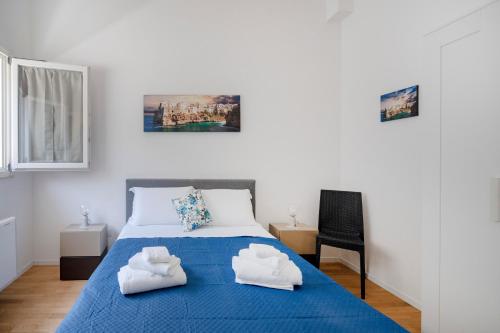 a bedroom with a blue bed with two white towels at Dimora Adriatica in Bari