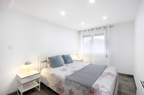 a white bedroom with a bed and a window at Guesthouse dos Limites in Espinho