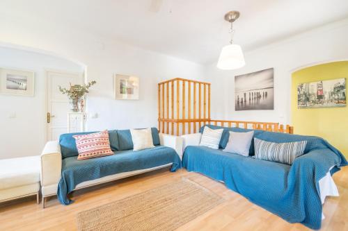 a living room with two blue couches at Villa Sant Vicente in Cala de Sant Vicenc