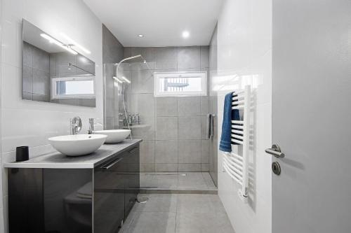 a white bathroom with two sinks and a shower at Guesthouse dos Limites in Espinho