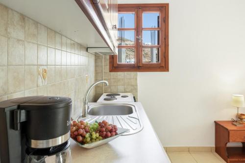 a kitchen with a sink and a bowl of grapes at Studios Asterias 4 in Astypalaia