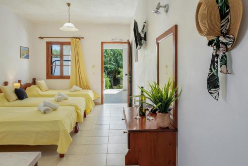 a hotel room with four beds and a hallway at Studios Asterias 4 in Astypalaia