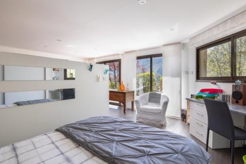 a bedroom with a bed and a desk and a chair at La Tour 74 in Thônes