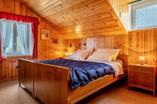 ein Schlafzimmer mit einem Bett in einem Holzzimmer in der Unterkunft Haus Botter in Klobenstein