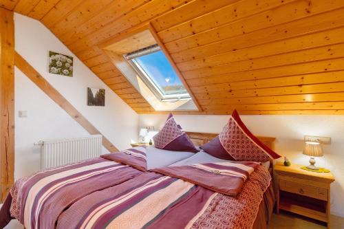 a bedroom with a large bed in a attic at Schwarzwald Buchenhof in Zell am Harmersbach