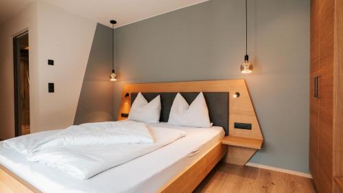 a bedroom with a bed with white sheets and pillows at Aktiv Lodge Meran - Terrace Large in San Martino