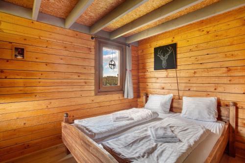 a bed in a wooden room with a window at Hof Keppel, der stromlose Urlaub in Schmallenberg
