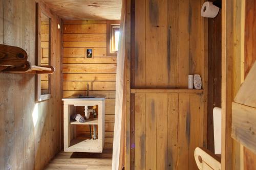 a hallway of a wooden cabin with a small cabinet at Hof Keppel, der stromlose Urlaub in Schmallenberg