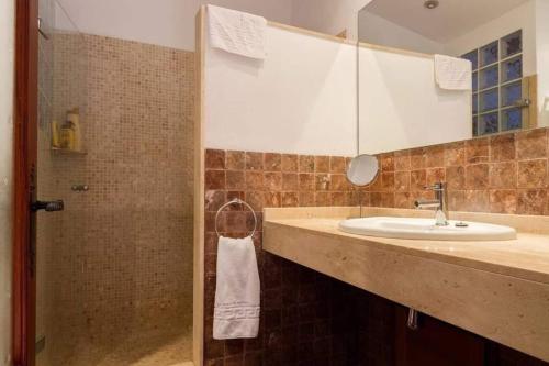 a bathroom with a sink and a shower with a mirror at Plana Morro in Pollença
