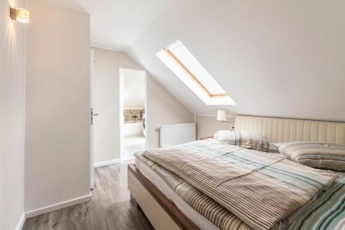a bedroom with a large bed and a skylight at Uhse Wohlfühloase in Heide